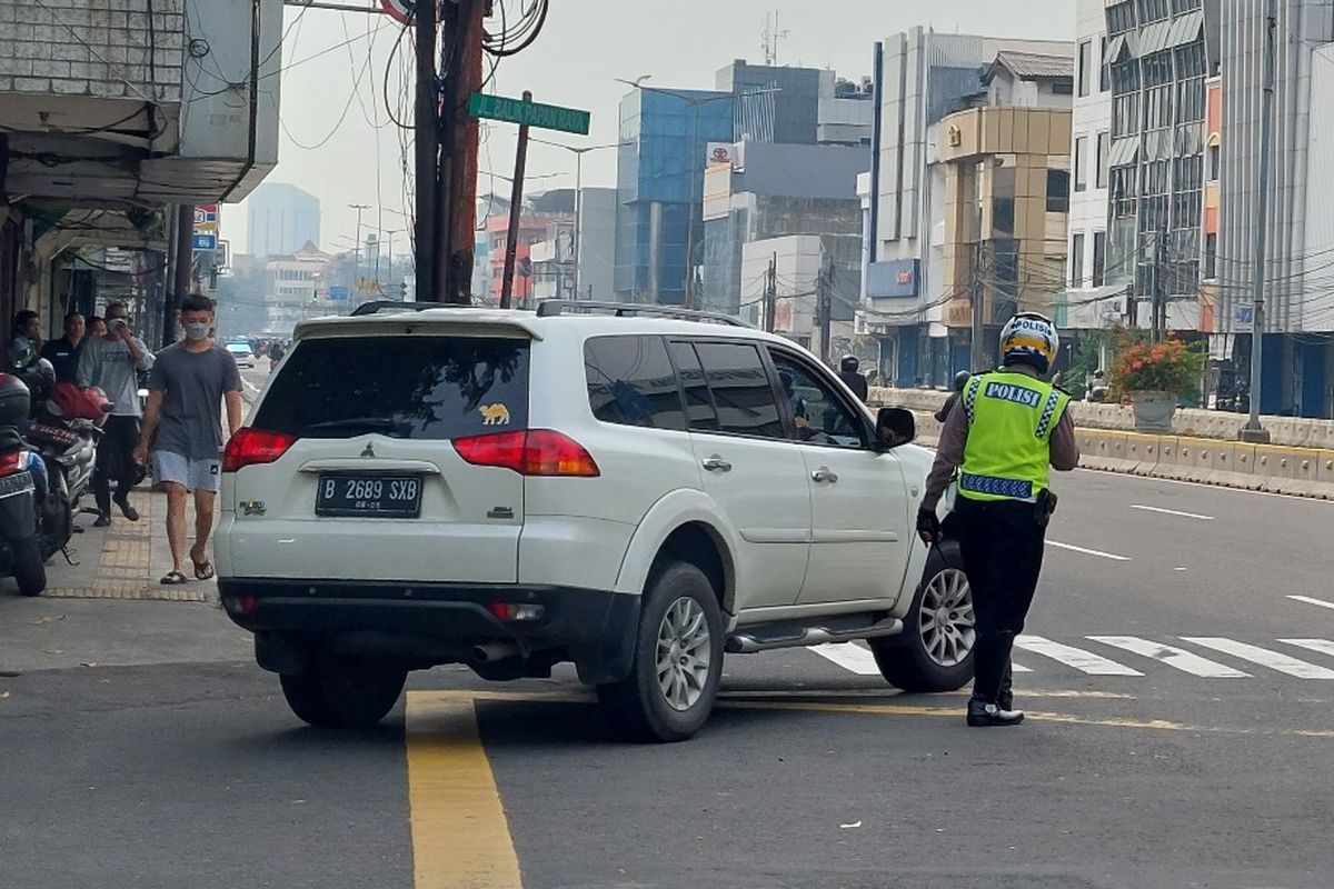 Polisi memberhentikan pelanggar ganjil genap di persimpangan dari Jalan Cideng Timur menuju Jalan Balikpapan Raya, Jakarta Pusat,  Senin (6/6/2022) pagi.