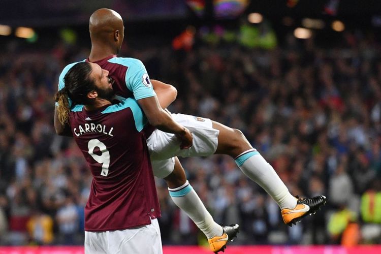 Andy Carroll dan Andre Ayew merayakan gol West Ham United ke gawang Huddersfield Town pada pertandingan Premier League di London Stadium, Senin (11/9/2017).