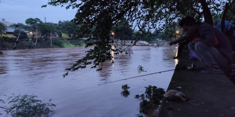 Warga memanfaatkan banjir di Jakarta untuk memancing di Kali Pesanggrahan, Rabu (1/1/2020), karena bisa lebih banyak mendapatkan ikan.