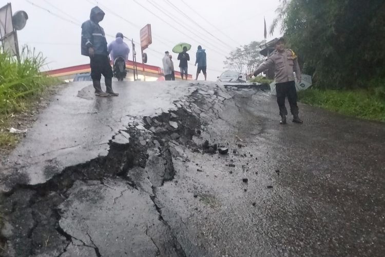 Seorang anggota Polsek Nyalindung menunjukkan retakan di Jalan Raya Sukabumi-Sagaranten, Kampung Cikawung, Desa/Kecamatan Nyalindung, Sukabumi, Jawa Barat, Rabu (4/12/2024).