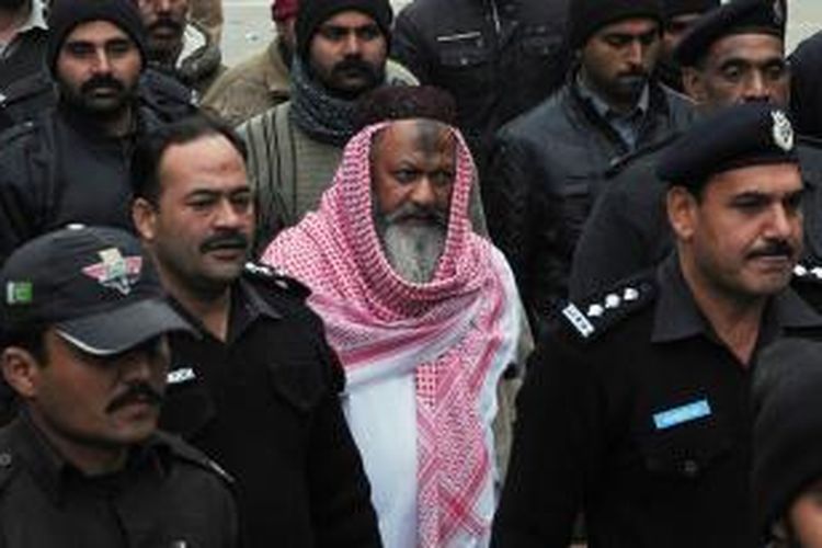 Dalam foto yang diambil pada Desember 2014 ini, polisi Pakistan nampak mengawal Malik Ishaq (tengah) pemimpin organisasi Lashkar-e-Jhangvi yang terlarang saat memasuki gedung pengadilan.