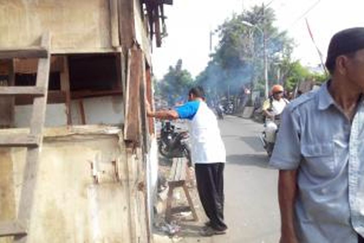 Seorang warga Duri Pulo membongkar warungnya sendiri karena melanggar fasum dan fasos, Senin (23/2/2015).