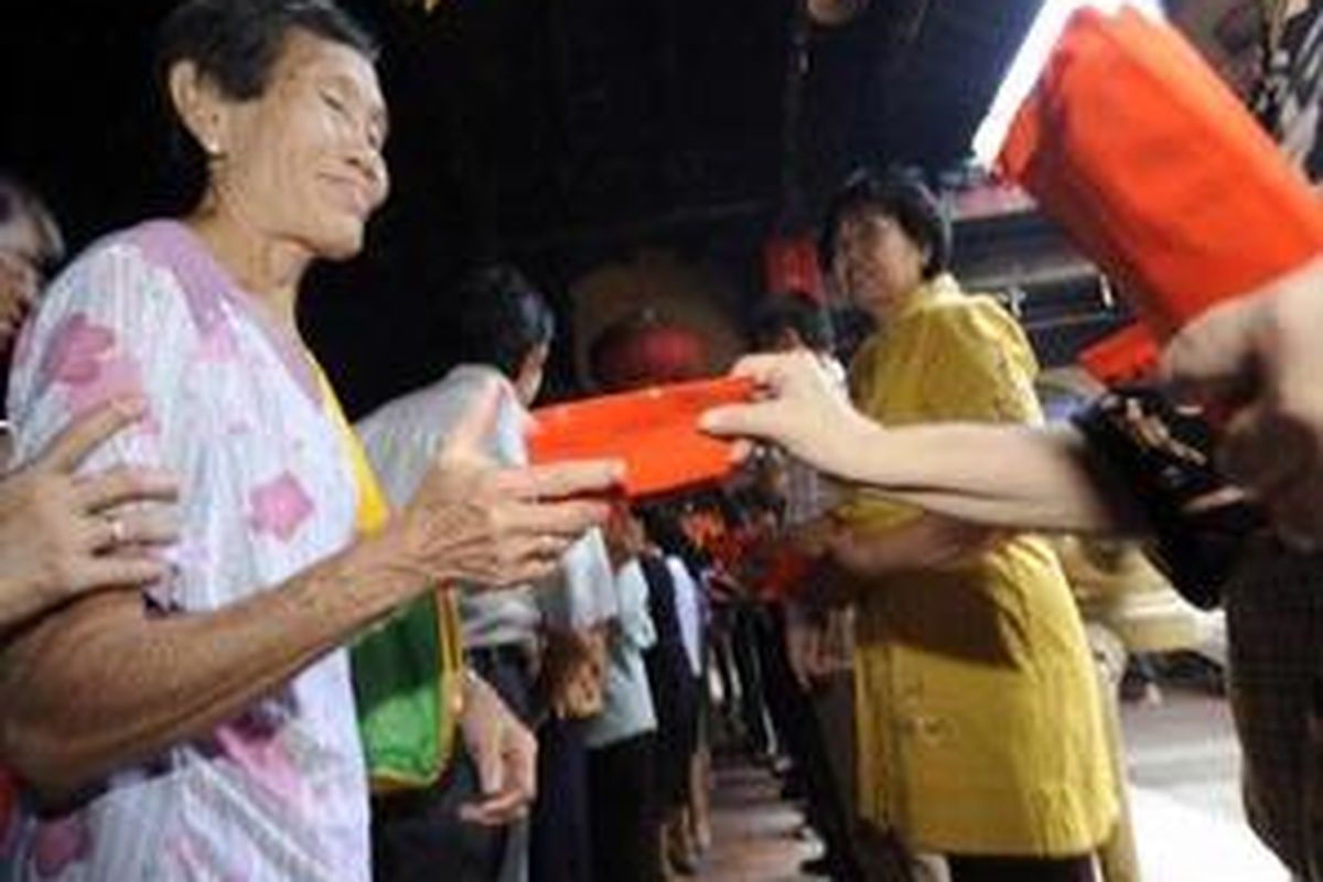 Pengurus dan donatur membagikan angpao kepada lansia yang kurang mampu di Klenteng Tay Kak Sie , Kota Semarang, Jawa Tengah, Minggu (18/1). Angpao dan bingkisan yang dibagikan kepada 1300 lansia tersebut diharapkan dapat dipergunakan untuk persiapan hari Raya Imlek. 
