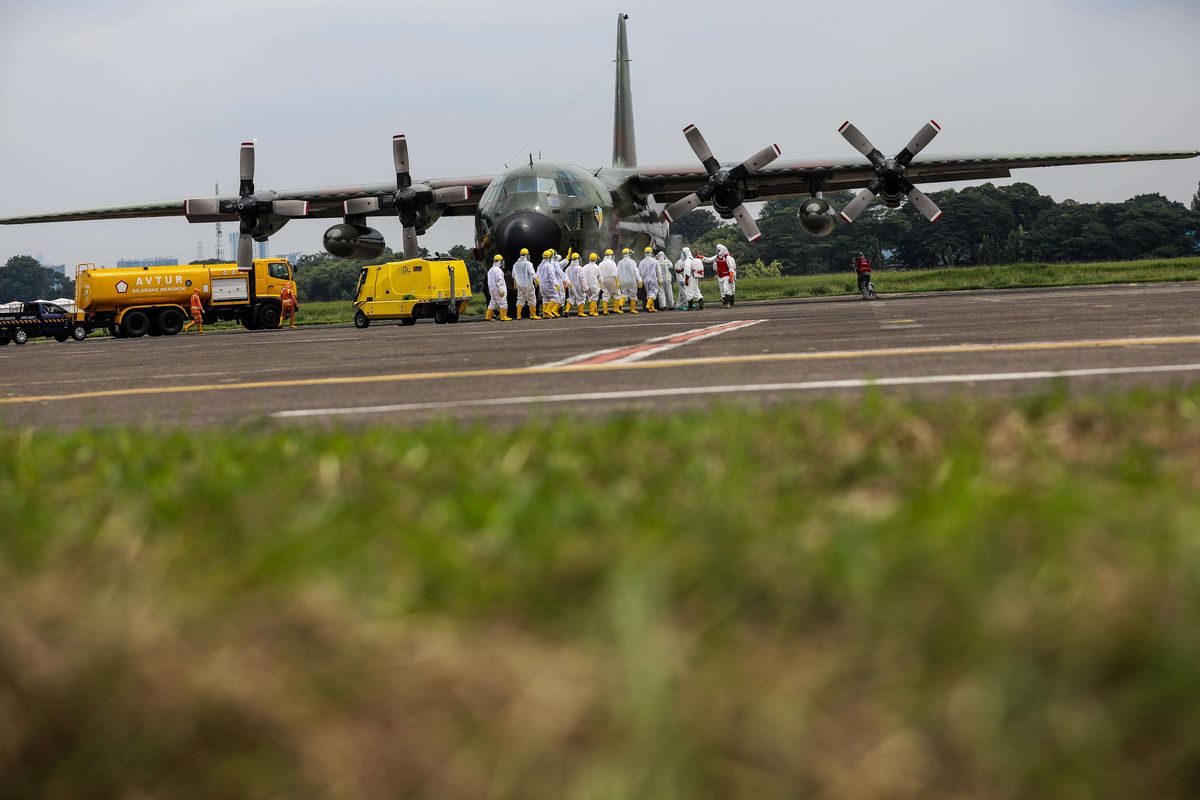 Petugas Palang Merah Indonesia menyemprotkan cairan disinfektan kepada petugas pengangkut alat kesehatan di Bandara Halim Perdanakusuma, Jakarta Timur, Senin (23/3/2020). Alat-alat kesehatan yang dibawa dari China untuk penanganan covid-19, yakni disposable mask, masker N95, APD, kacamata goggle, sarung tangan, pelindung sepatu, termometer infrared, dan lainnya.