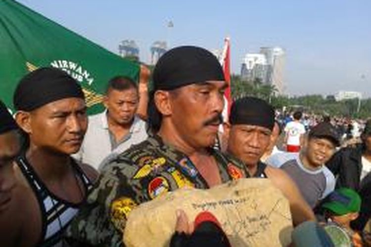 Kopral Bagyo saat memperlihatkan batu seberat 15 kilogram yang ditandatangani oleh Gubernur DKI Jakarta Joko Widodo dalam aksi memutati Monas 25 Jam, Minggu (7/7/2013)