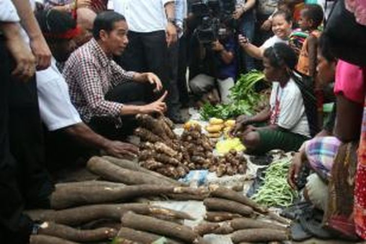Calon presiden Joko Widodo (Jokowi) membeli keladi dari pedagang di Pasar Baru Sentani, Jayapura, Papua, Kamis (5/6/2014). Pasar Baru Sentani menjadi tempat pertamanya memulai rangkaian kampanye pilpres di kawasan ujung timur Indonesia.