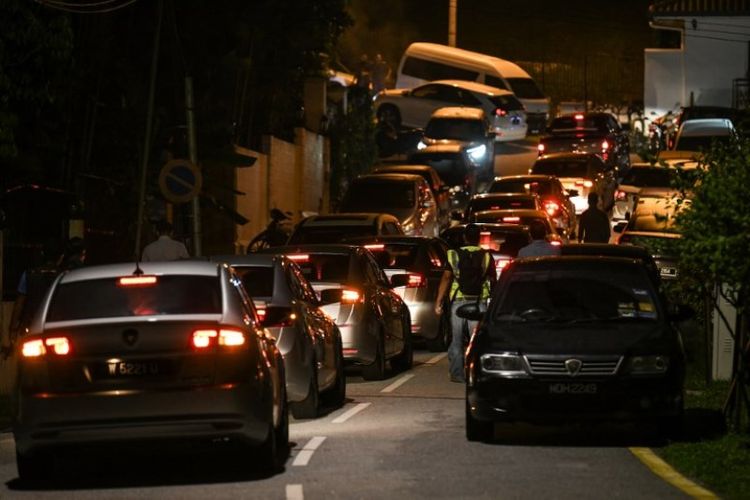 Mobil polisi Malaysia berada di jalan sekitar kediaman mantan perdana menteri Najib Razak di Kuala Lumpur pada Rabu (16/5/2018). (AFP/Mohd Rasfan)