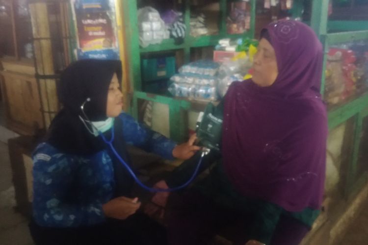 Salah seorang Pelajar SMK Giri Handayani, Wonosari, Gunungkidul Melakukan Pemeriksaan Tekanan Darah kepada Pedagang Pasar Argosari, Wonosari