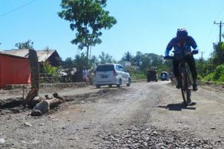 Peserta Kompas Jelajah Sepeda Manado Makassar melewati jalan rusak dj Jalan Trans Sulawesi dari Kota Gorontalo menuju Marisa, Jumat (22/8/2014).