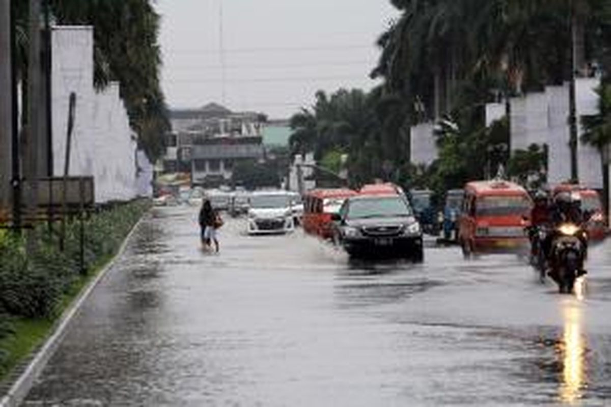 Pengendara melintasi genangan di Jalan boulevard, Kelapa Gading  Jakarta Utara, Jumat (17/1/2014). Hujan lebat mengguyur Jakarta sejak pagi, membuat sejumlah jalanan Ibukota tergenang. 