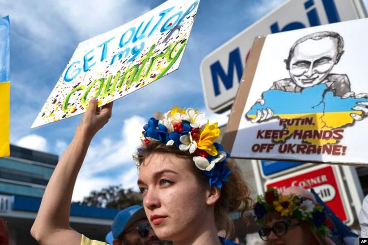 Seorang perempuan Ukraina mengacungkan poster dalam demo memprotes invasi Rusia ke Ukraina, di Los Angeles, AS, Sabtu, 26 Februari 2022.