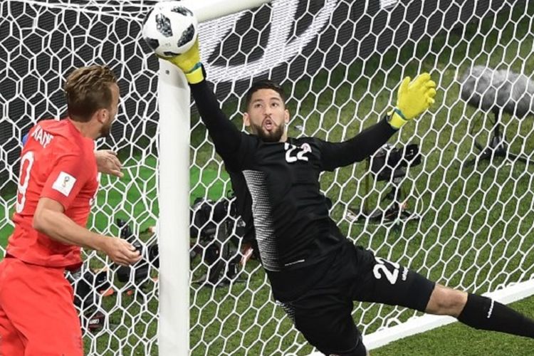 Kiper Tunisia, Mouez Hassen, mencoba menahan sundulan penyerang Inggris, Hary Kane, pada pertandingan di Volgograd Arena, 18 Juni 2018. 