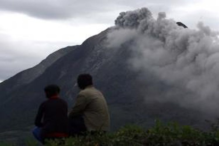 Sejumlah warga mengamati kondisi Gunung Sinabung yang sedang mengeluarkan debu vulkanik pasca meletus di Kabupaten Karo, Sumut, Minggu (15/9/2013). Letusan Gunung Sinabung di Kabupaten Karo pada Minggu (15/9) pukul 02.51 WIB menyebabkan ribuan warga dari belasan desa di bawah kaki gunung tersebut terpaksa diungsikan karena statusnya dinyatakan berbahaya. 