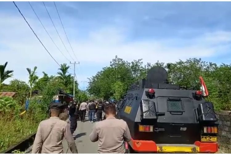 Polisi saat akan membubarkan massa yang muncul dari gang jalan untuk menuju ke Kantor DPRD Mimika berunjuk rasa, Senin (18/4/2022).