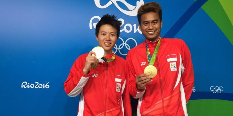 Liliyana Natsir dan Tontowi Ahmad memamerkan medali emas yang diraihnya di Olimpiade Rio 2016, Rabu (17/8/2016).