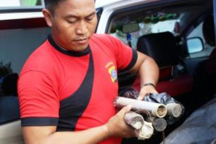 Seorang anggota polisi sedang mengamankan barang yang dicurigai merupakan bom rakitan di Kabupaten Talaud.