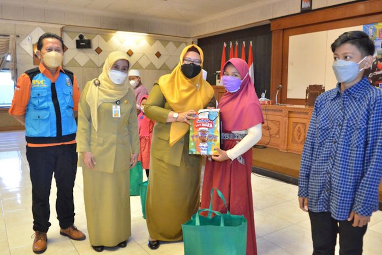 Wakil Bupati Gresik Aminatun Habibah (tengah), saat memberikan bantuan kepada anak yatim piatu yang ditinggal orangtua mereka usai terpapar Covid-19, Senin (9/8/2021).