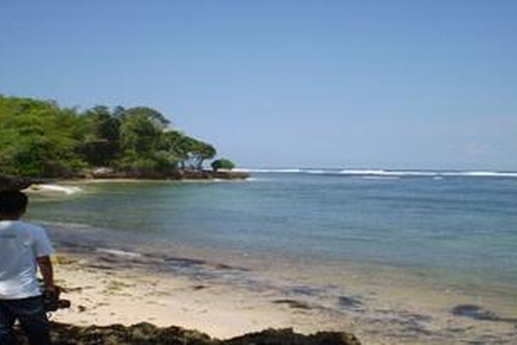 Seorang pengunjung pantai Plengkung di Banyuwangi tengah mencari titik bidik lensa kameranya. Pada saat musim gelombang, pantai tersebut banyak dikunjungi para peselancar.