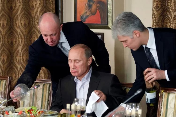 Foto November 2011 menunjukkan Yevgeny Prigozhin (kiri) membantu Vladimir Putin di sebuah perjamuan dekat Moskwa.