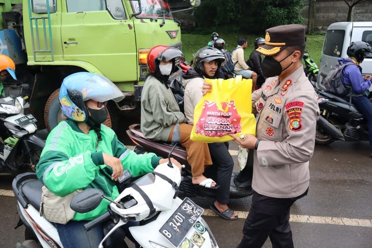 Kapolres Tangerang Selatan AKBP Sarly Sollu saat membagikan paket sembako kepada masyarakat di Jalan Letnan Soetopo, Tangsel, Banten, Kamis (8/9/2022) 