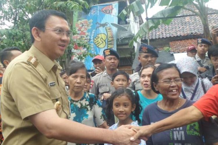 Gubernur DKI Jakarta Basuki Tjahaja Purnama bersalaman dengan warga Bukit Duri, Senin (20/2/2017). 
