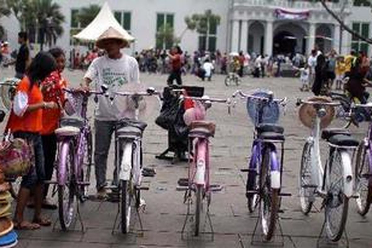 Ropik tengah melayani calon pelanggannya yang hendak menyewa sepeda di halaman Museum Fatahillah, Jakarta, Minggu (2/1/2011). Hari libur mendatangkan rezeki lebih bagi Ropik dan teman-temannya yang menyewakan sepeda di kawasan wisata Kota Tua. Mereka mengenakan tarif Rp 20.000 per jam bagi para penyewa untuk mengelilingi kawasan tersebut.