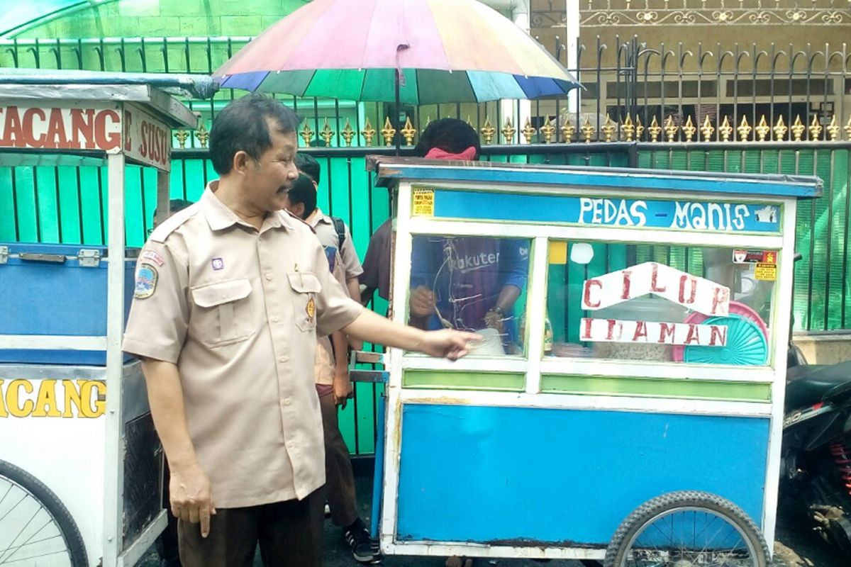 Kepala Sekolah SD Negeri 01 Pagi Tanjung Duren, Jakarta Barat saat menunjukkan gerobak  tempat ketiga muridnya membeli cilok sebelum percobaan penculikan terjadi, Rabu (13/9/2017). 