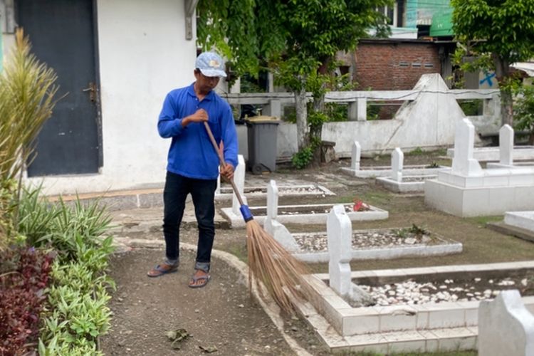 Safiin, saat membersihkan TMP Ngagel, Surabaya, Senin (17/11/2025).