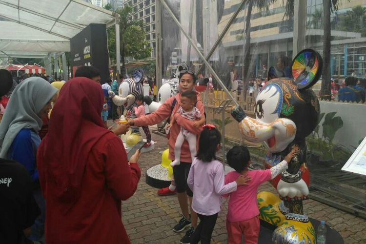 Publik berfoto bersama patung replika Mickey Mouse dalam acara perayaan hari jadi ke-90 karakter animasi Mickey Mouse, yang diadakan pada kegiatan Car Free Day di kawasan Sarinah, Jalan MH Thamrin, Jakarta Pusat, Minggu (18/11/2018).