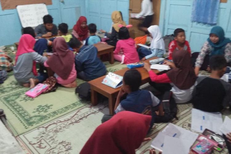 BELAJAR—Anak-anak di Desa Jimbar, Kecamatan Pracimantoro, Kabupaten Wonogiri sementara belajar didampingi relawan di sanggar belajar. Pemerintah Desa Jimbar mengeluarkan peraturan desa yang melarang warganya bermain hp dan menyalakan televisi saat jam belajar diberlakukan.