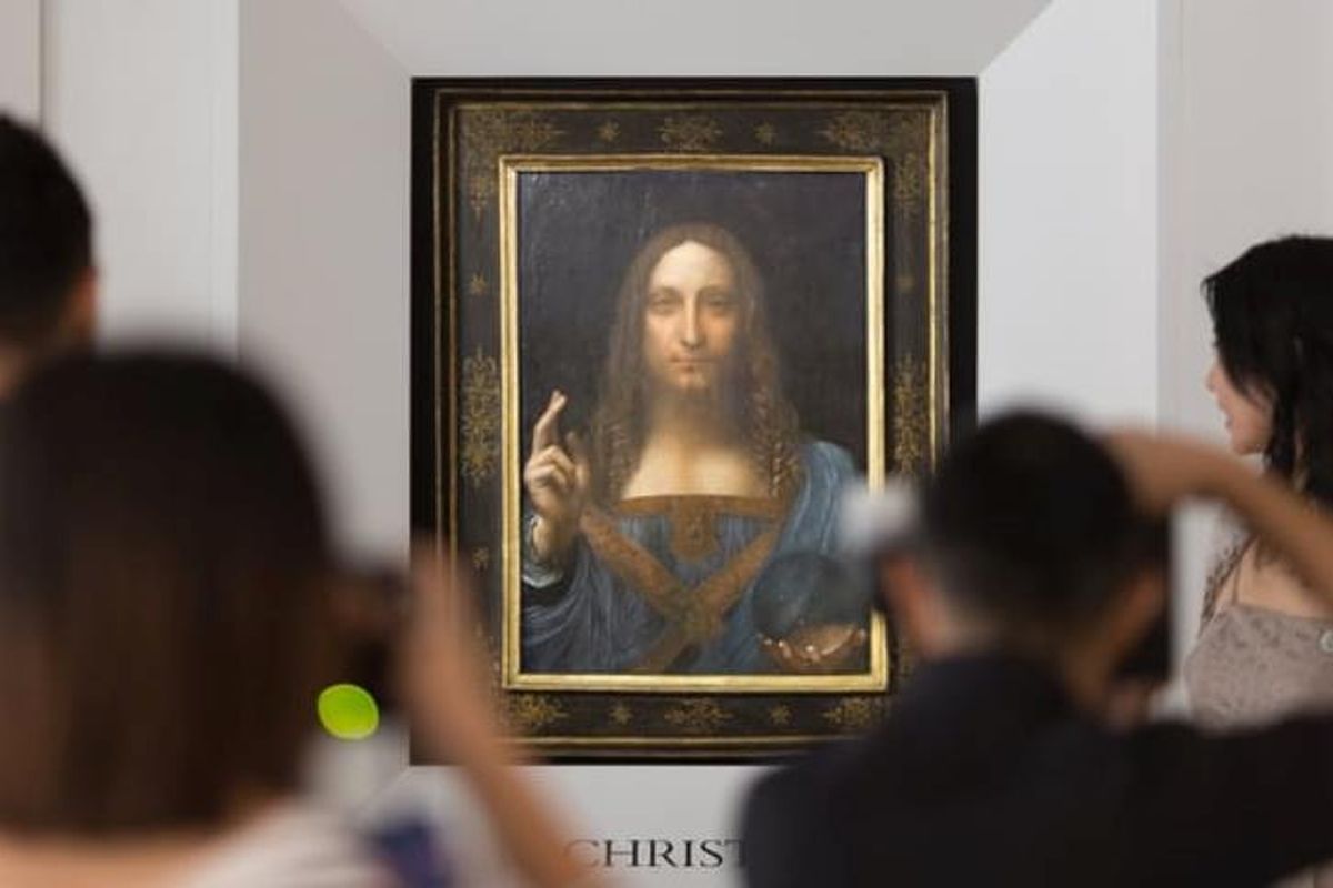 Orang-orang memotret lukisan Salvator Mundi yang tengah dipamerkan. Lukisan ini diragukan karena bola kristal yang dibawa Yesus Kristus tidak membelokkan cahaya.