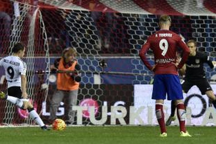 Penyerang Valencia Paco Alcacer (kiri) melakukan tendangan penalti dalam pertandingan La Liga melawan Atletico Madrid di Vicente Calderon, Minggu (25/10/2015).