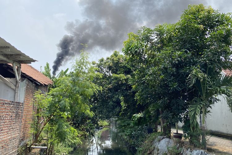 Asap hitam pekat yang muncul dari cerobong pabrik tahu di Tropodo, Krian, Sidoarjo, Jumat (22/8/2025)