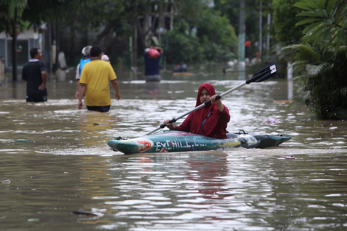 Warga menaiki kayak menembus banjir yang merendam perumahan Villa Jatirasa, Jatiasih, Kota Bekasi, Jawa Barat, Minggu (25/10/2020). Banjir akibat luapan Kali Cikeas dan Kali Cileungsi--induk Kali Bekasi--dengan ketinggian 60 cm hingga dua meter itu melanda sejumlah perumahan pada Sabtu (24/10/2020) pukul 23.00 WIB. Badan Penanggulangan Bencana Daerah Bekasi dibantu Basarnas mengevakuasi sebagian warga ke daerah yang lebih aman.