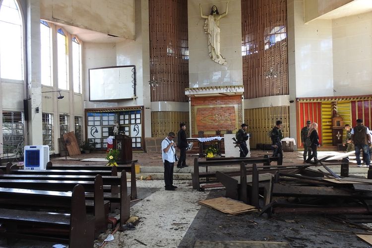 Aparat Filipina memeriksa lokasi ledakan bom di dalam gereja Katolik di Jolo, Provinsi Sulu, sehari setelah insiden, Senin (28/1/2019).