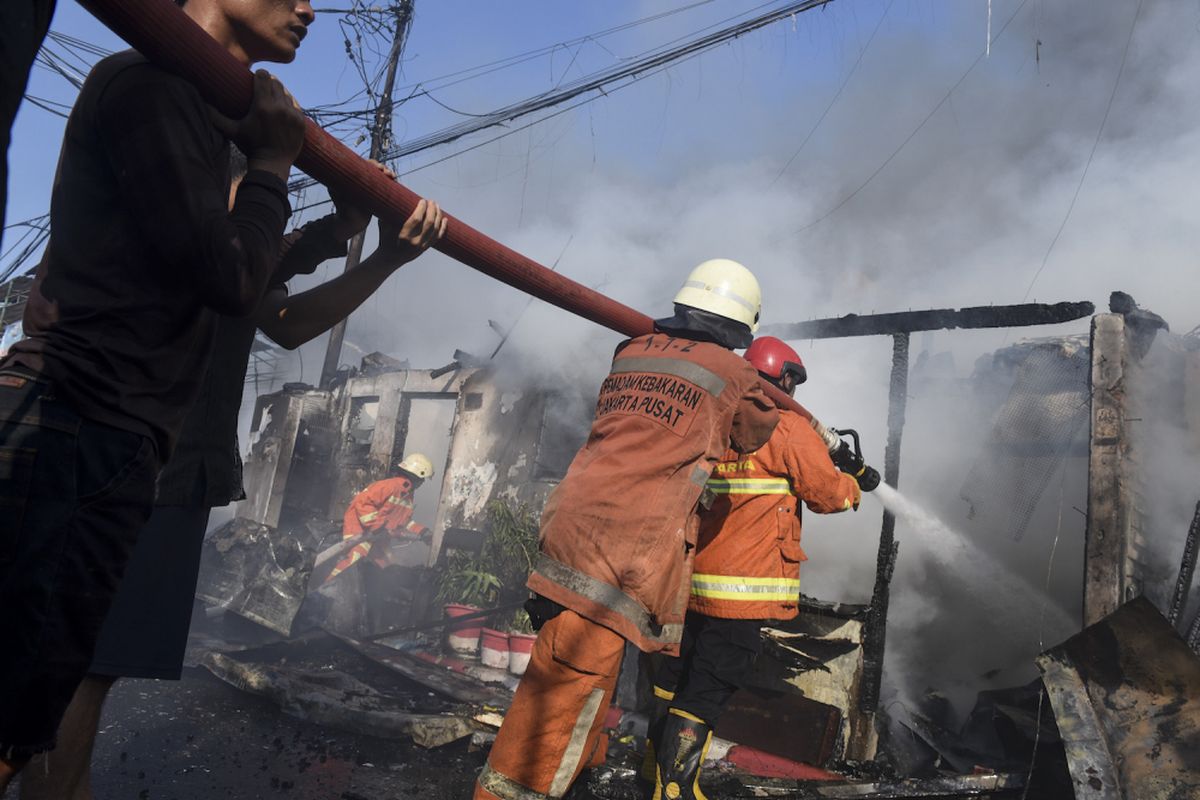 Petugas pemadam kebakaran berusaha memadamkan api saat terjadi kebakaran di kawasan Bendungan Hilir, Jakarta, Sabtu (9/9/2017). lebih dari 15 unit mobil pemadam kebakaran dikerahkan untuk memadamkan api yang membakar pemukiman padat penduduk itu. 