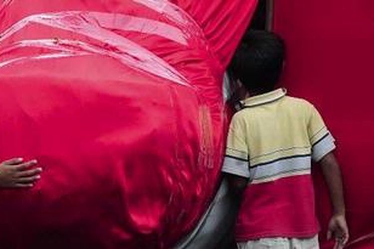 Anak-anak mengintip patung Laksamana Cheng Ho yang didatangkan dari China di halaman Klenteng Sam Poo Kong, Kota Semarang, Jawa Tengah, Jumat (14/1/2011). Patung tembaga setinggi sekitar 10 meter ini menjadi salah satu penanda jejak Laksamana Cheng Ho yang melaksanakan diplomasi, pertukaran budaya, dan penyebaran agama saat ekspedisi maritimnya pada abad ke-15. 