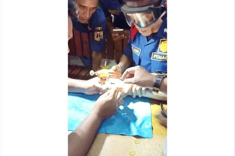 Pemadam dari Suku Dinas Penanggulangan Kebakaran dan Penyelamatan (PKP) Jakarta Timur bantu pemuda lepaskan cincin dari jarinya, Senin (29/7/2019).