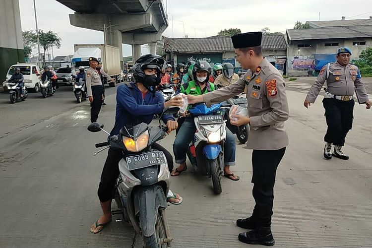 Jajaran Polsek Cakung membagikan takjil gratis kepada para pengguna jalan yang melintasi Jalan Bekasi Raya, Cakung, Jakarta Timur, Kamis (14/3/2023) sore.