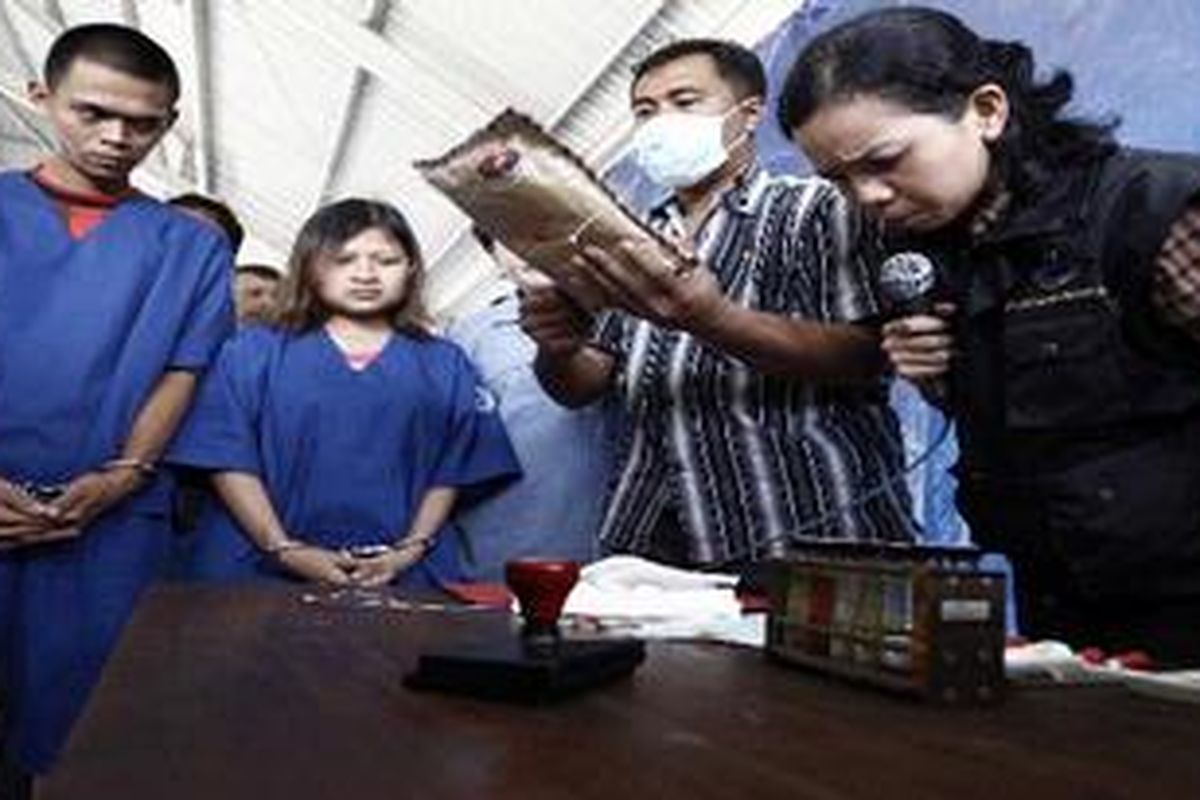 Ariep Ramdani (kanan) dan Siti Asiyah, dua tersangka kurir narkotika jenis Heroin ikut menyaksikan tes uji laboratorium oleh petugas di halaman belakang Gedung Badan Narkotika Nasional (BNN), Jakarta Selatan, Kamis (15/7/2010). Sebanyak 871,5 gram heroin berhasil diamankan petugas saat mereka melakukan transaksi di taman Rumah Sakit Cipto Mangunkusomo Kamis (1/7/2010) lalu.