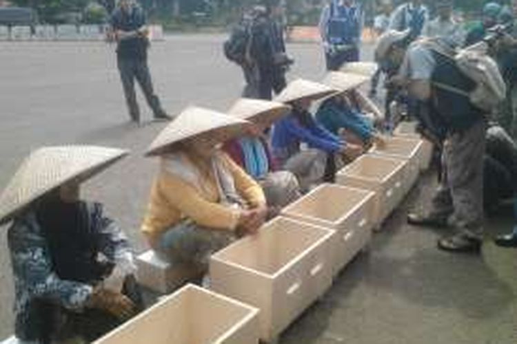 Para petani berunjuk rasa di depan Istana Negara, Selasa (12/4/2016) dengan mengecor kaki mereka sebagai bentuk protes pembangunan pabrik semen di kawasan Pegunungan Kendeng, Jawa Tengah.