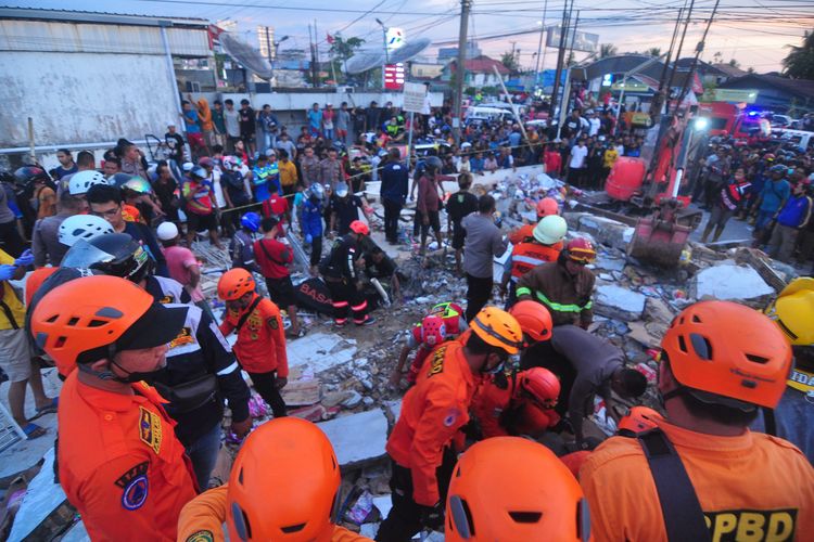 Tim SAR mengevakuasi korban yang terjebak di reruntuhan gedung retail modern Alfamart di Gambut Km 15, Kabupaten Banjar, Kalimantan Selatan, Senin (18/4/2022). Sebanyak 17 orang menjadi korban dalam peristiwa tersebut, lima korban diantaranya berhasil dievakuasi dan hingga kini tim gabungan terdiri dari Basarnas, TNI, POLRI dan relawan dibantu sejumlah alat berat masih terus berupaya melakukan evakuasi korban yang masih terjebak reruntuhan gedung retail modern Alfamart.