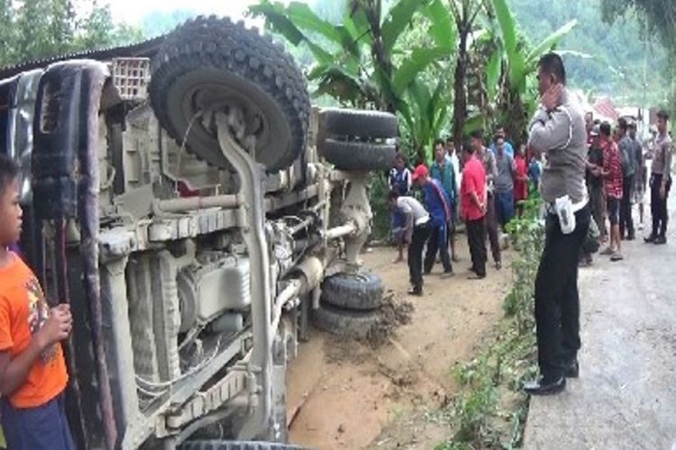 Truk pengangkut aspal panas, terbalik dan menimpa sebuah motor dan rumah milik warga di Tusan, Desa Tondok Bakaru, Kecamatan Mamasa, kabupaten Mamasa sulawesi barat, Minggu (13/8).