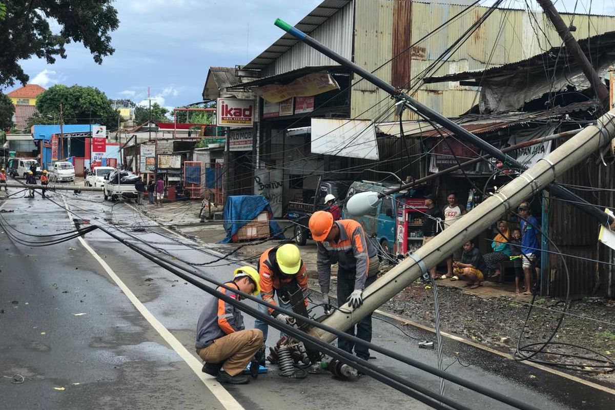 Petugas tengah menangani tiang listrik yang roboh di Jalan Raya Kalimulya, Cilodong, Depok pada Kamis (9/2/2023).