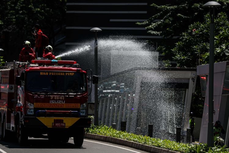 Petugas Pemadam Kebakaran (Damkar) menyemprotkan disinfektan di sepanjang jalan protokol dari monas sampai bunderan senayan di Jakarta, Selasa (31/3/2020). Penyemprotan disinfektan dalam rangka mitigasi pencegahan virus corona (COVID-19).