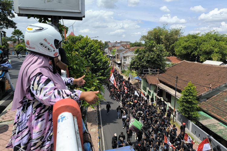 Siti Zubaidah dan suaminya, Suhdi mengacungkan jempol kepada massa aksi di Jember, Sabtu (30/8/2025).
