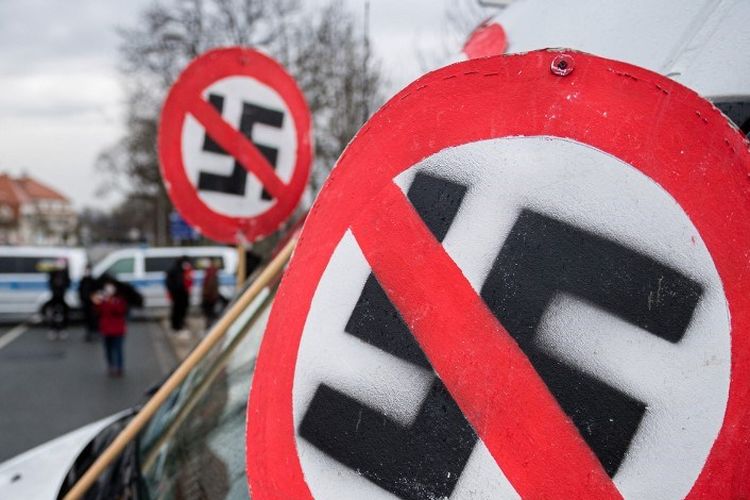 Sebuah tanda larangan dengan swastika terlihat di kap mobil selama demonstrasi di dekat tempat pameran di Dresden, Jerman timur pada 10 April 2021, di mana kongres partai AfD (Alternative fuer Deutschland) sayap kanan berlangsung. 
