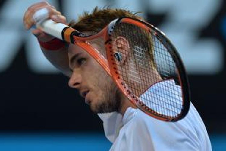 Petenis Swiss, Stanislas Wawrinka mengelap keringat saat pertandingan semifinal Australian Open melawan petenis Ceko, Tomas Berdych, yang berlangsung di Rod Laver Arena, Melbourne Park, Kamis (23/01/2014).