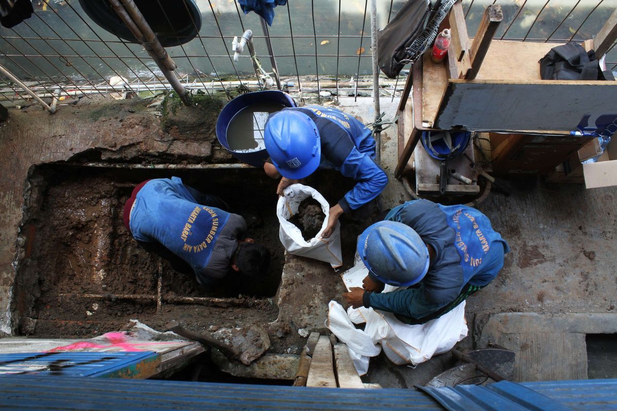 Pekerja menggali tanah yang sudah diberi titik untuk pembuatan septik tank di Gang Sekretaris I, Tanjung Duren Jakarta Barat, Rabu (9/10/2019). Ada sekitar 21 titik lubang galian yang dibuat di sepanjang gang.