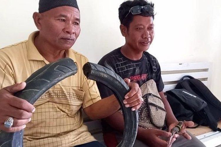 Tili (kanan) seorang penangkap buaya berkalung ban di Kota Palu, Sulteng, memelihara burung di rumahnya. 
